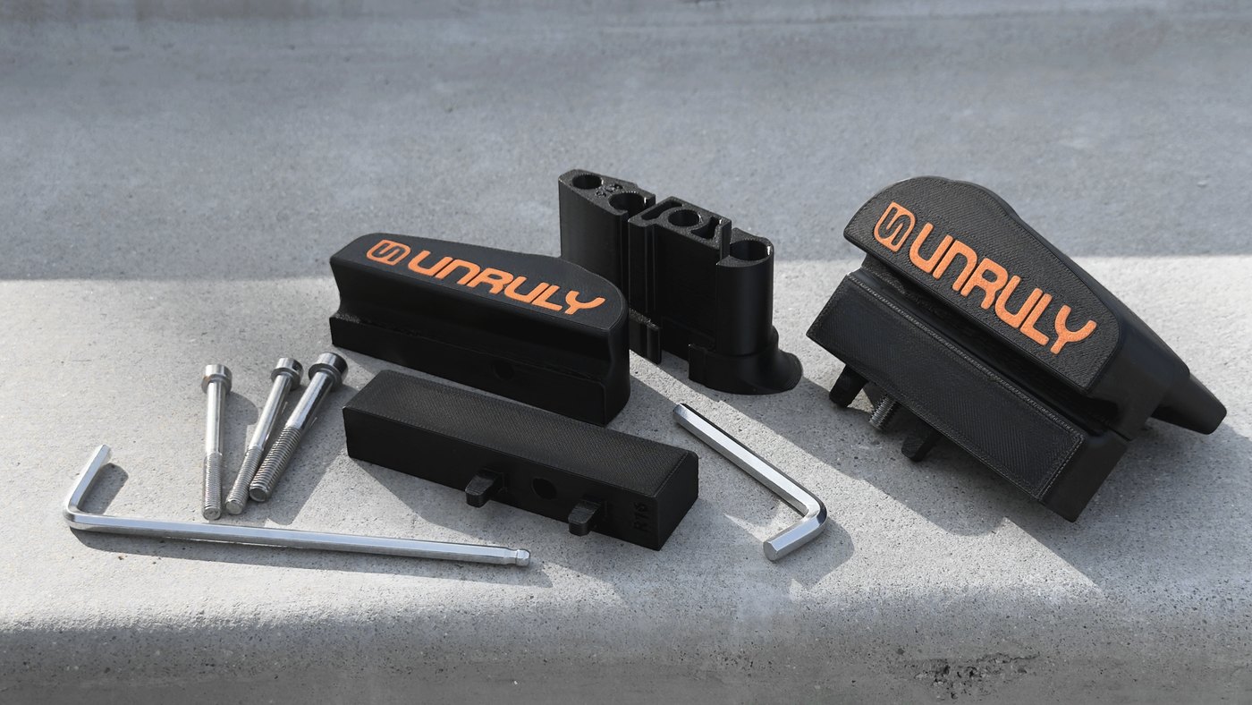 Black FDM printed mounting blocks with an orange two-colour logo